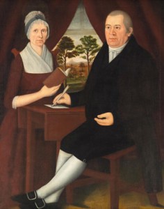 Mr. and Mrs. Brewster, seated. She wears a round-eared cap