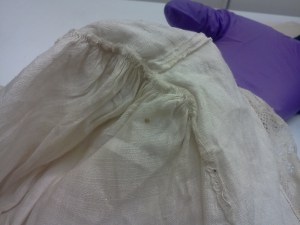 Close-up of top of cap, showing join of the headpiece and gathers of the caul. 