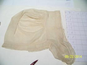 Lappet cap laid out on graph paper for size. 