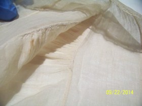 View inside this cap, showing neat rolled gather stitches. 