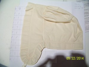 Lappet cap laid out on graph paper, showing size. 