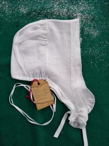 Saines' repro of double ruffle cap on green background, with snow. 