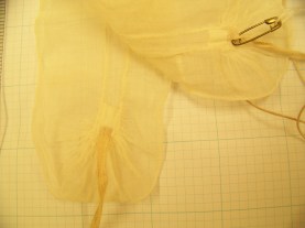 With one lappet folded back, the turn of the ruffle and the skinniness of the lappet are visible. 