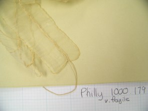 The gather is accomplished by leaving gaps in the vertical seam down the middle of the lappet, and weaving the stings in and out. 